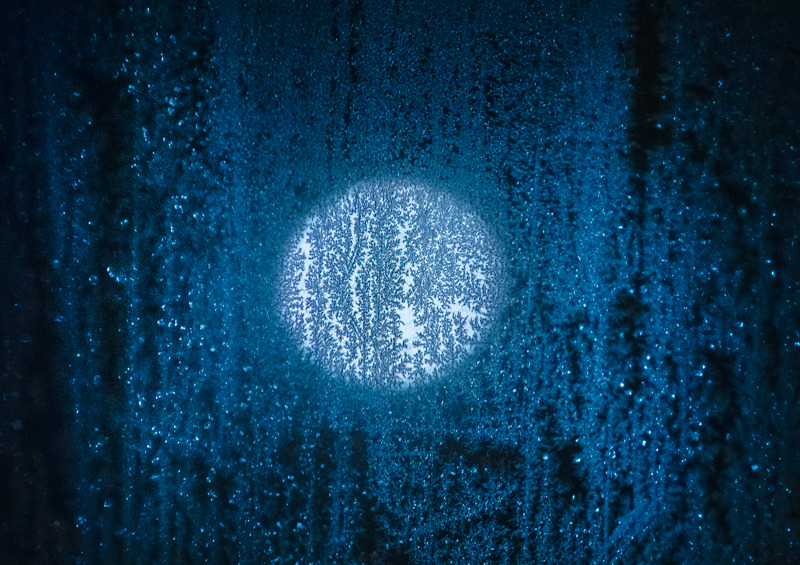 Зимовий вечір, через змерзле вікно видно повний місяць